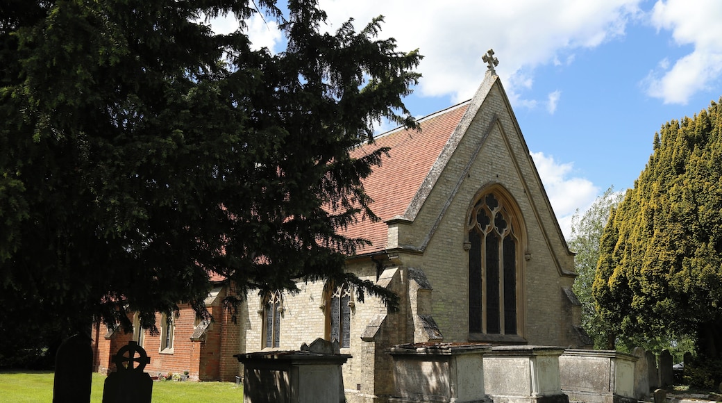 St Germain's Church, Bobbingworth, Essex, England - chest tombs and graves under a yew tree against the buttressed chancel east wall, from the south-east