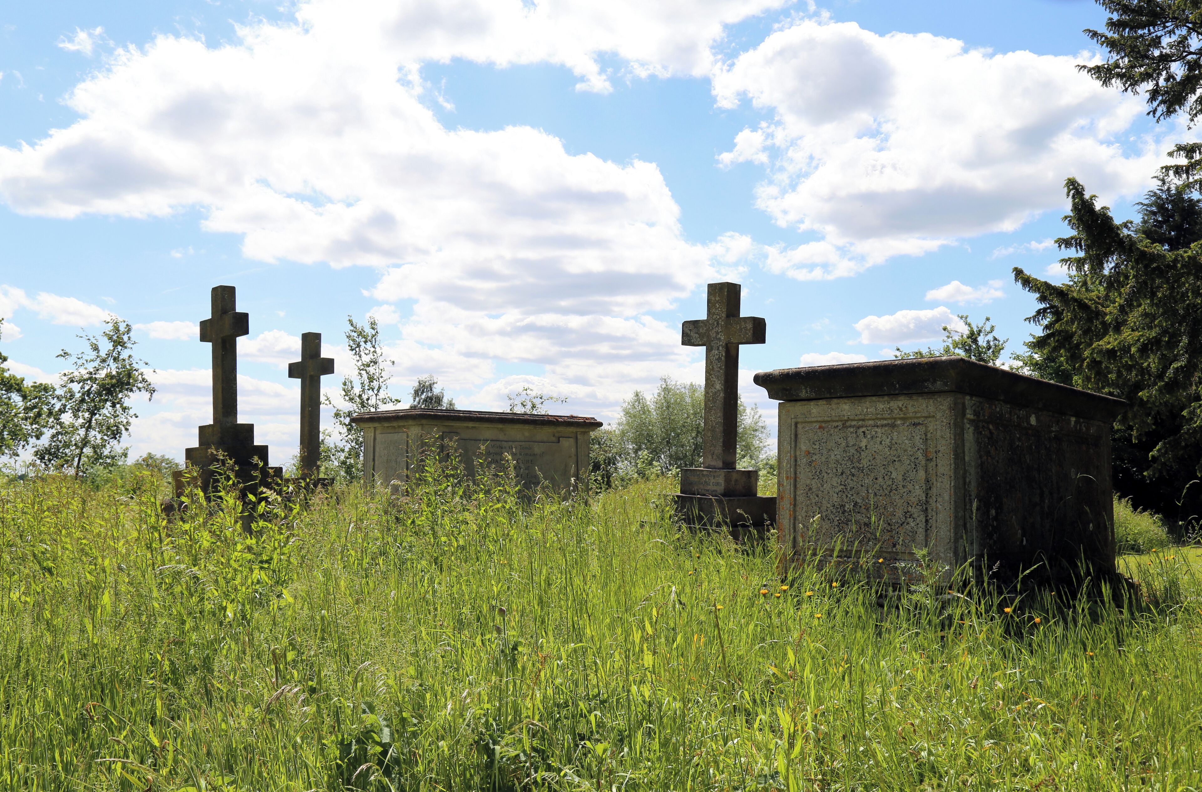 St Germain's Church, Bobbingworth, Essex, England - chest tombs and cross grave markers at the south-east in overgrown churchyard