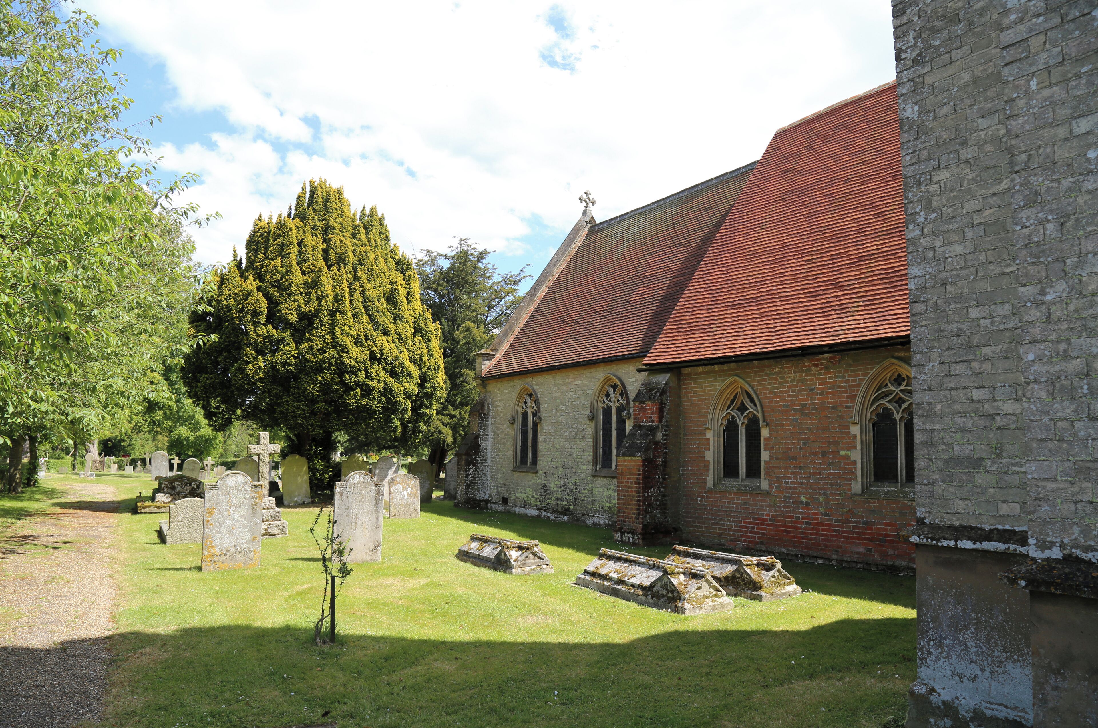 St Germain's Church, Bobbingworth, Essex, England - buttressed nave and chancel, and graveyard with trees, including yew, at the north, looking east from the tower