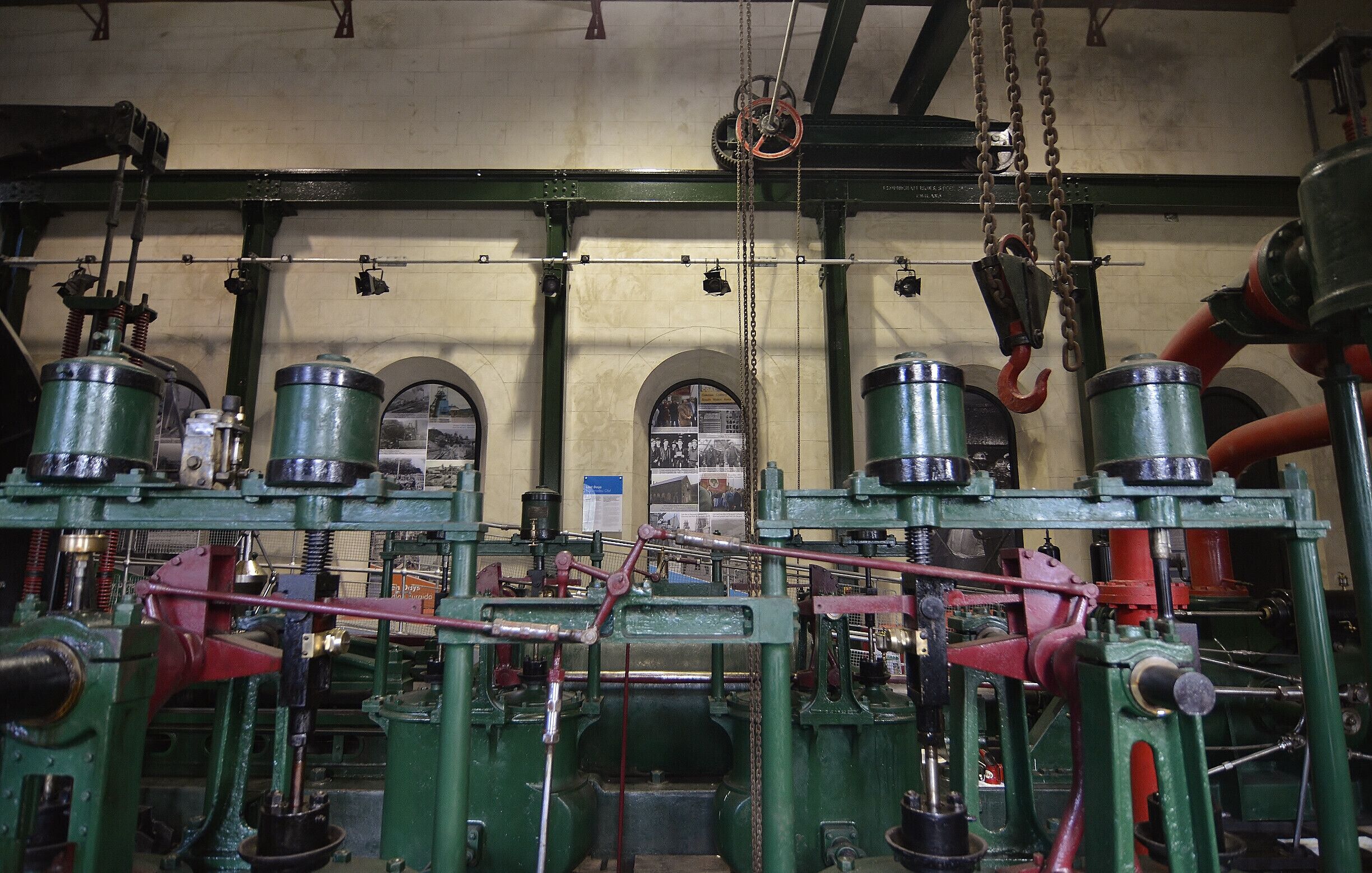 Industrial machinery with green and red components, chains, and pulleys.