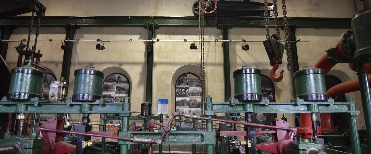 Industrial machinery with green and red components, chains, and pulleys.