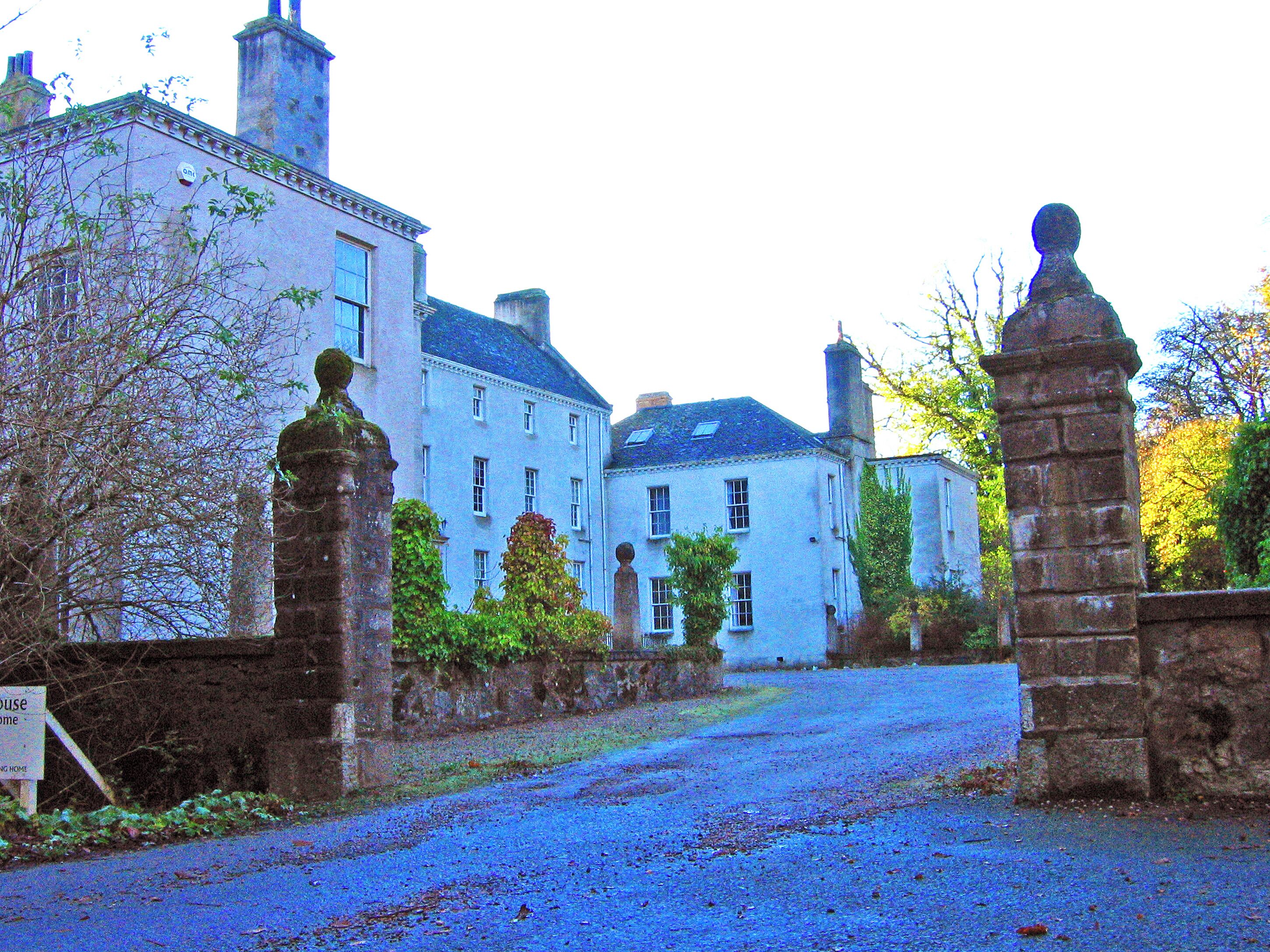 A historic building with a stone gate and a sign that reads "House Home."
