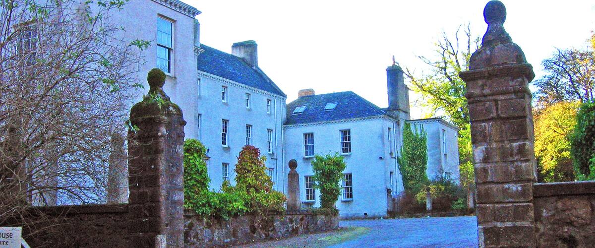 A historic building with a stone gate and a sign that reads "House Home."