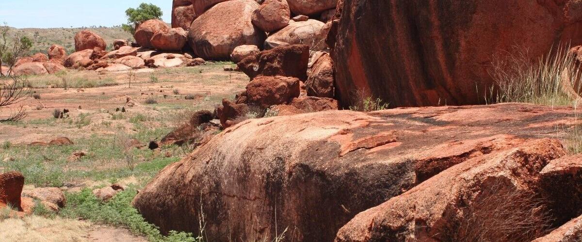 A rocky landscape with large boulders and sparse vegetation.