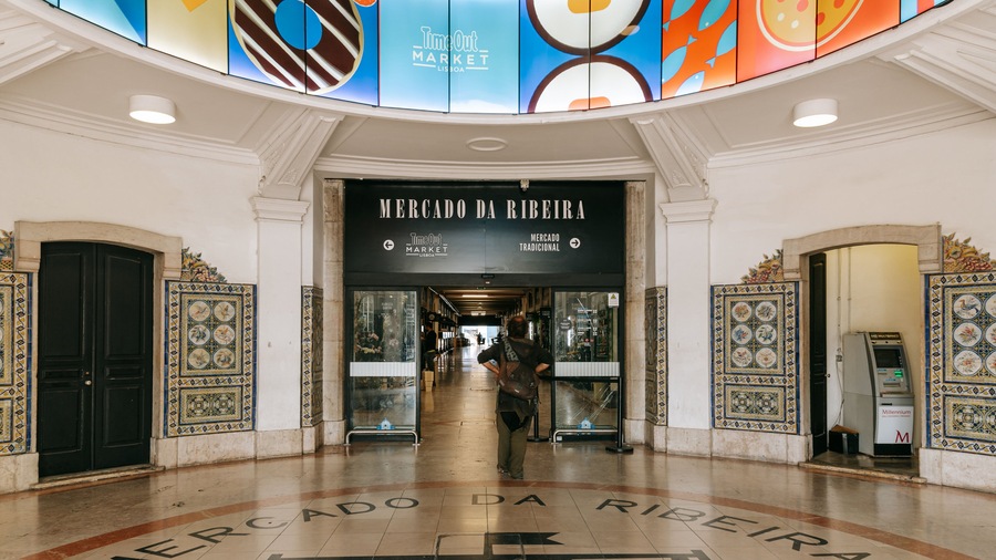 La entrada del Mercado da Ribeira con letreros de mercado tradicionales y modernos.