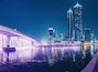 Illuminated waterfall bridge in downtown Dubai at night with thousands of small lights on high skyscrapers. Popular tourist attractions in UAE