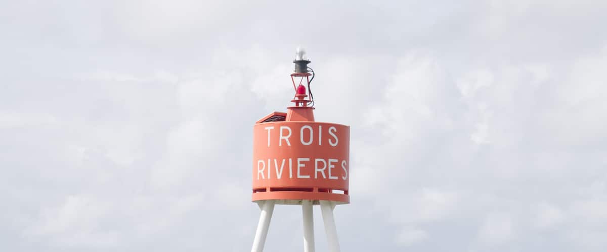 A buoy with the text "TROIS RIVIERES" in the ocean.