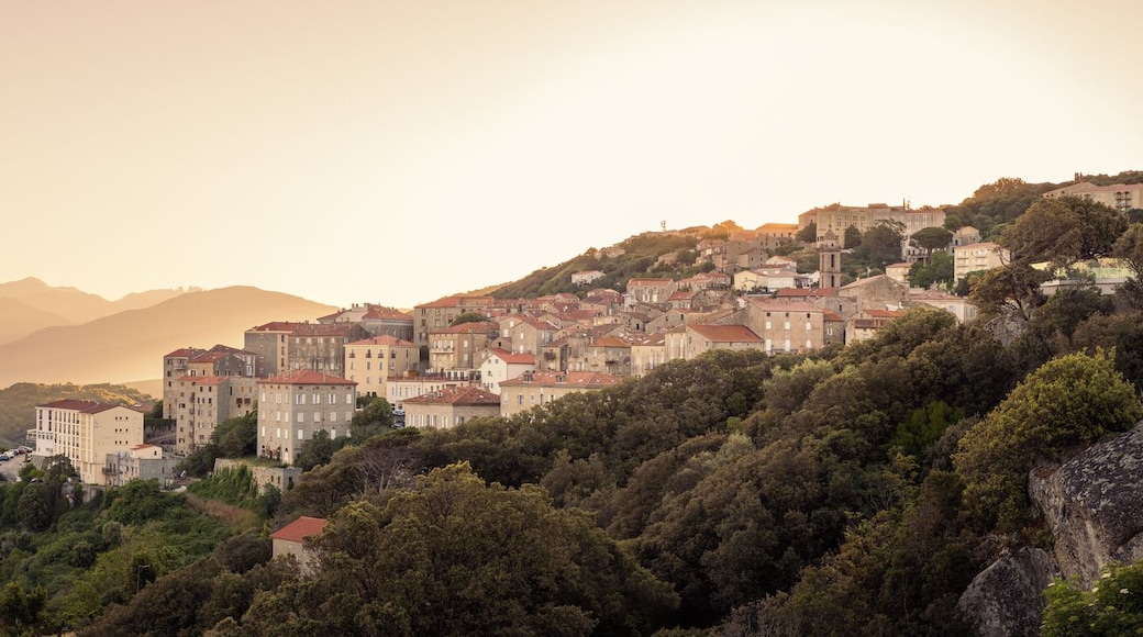 Un paysage montagneux avec une ville construite sur une falaise.