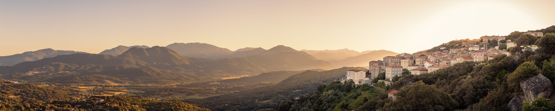 Un paisaje montañoso con un pueblo asentado en un acantilado.