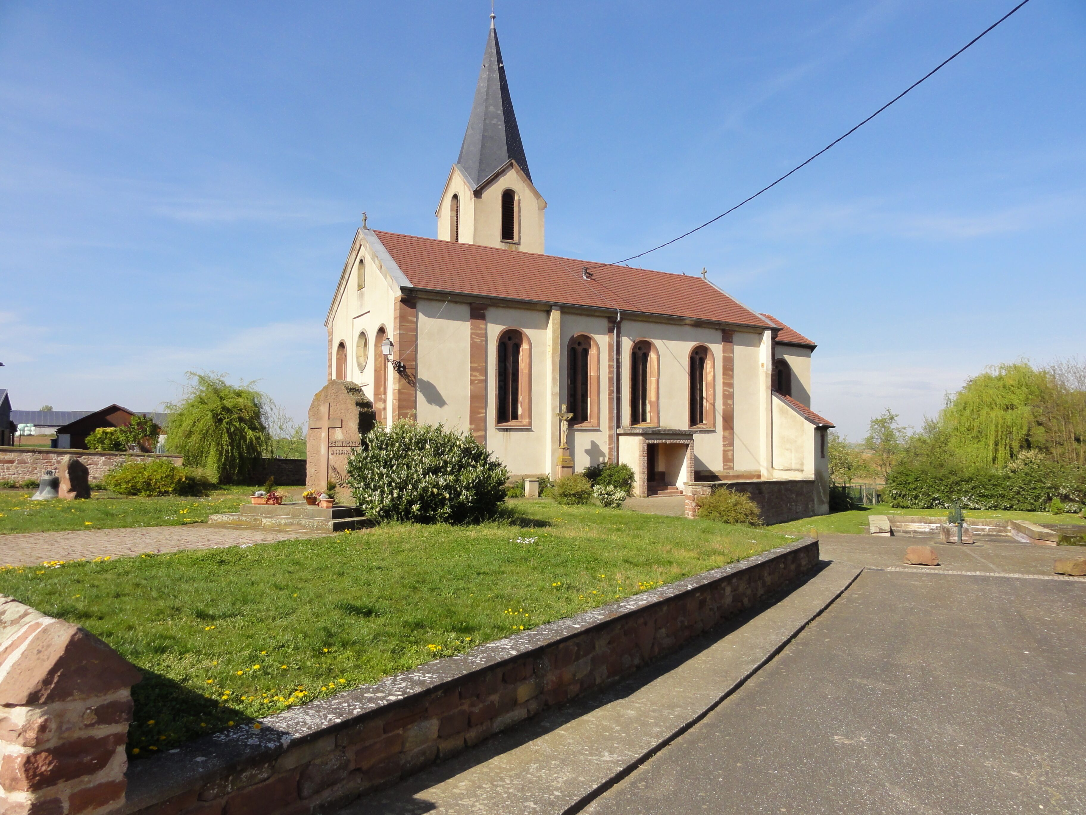A church with a tall steeple and a red roof.
