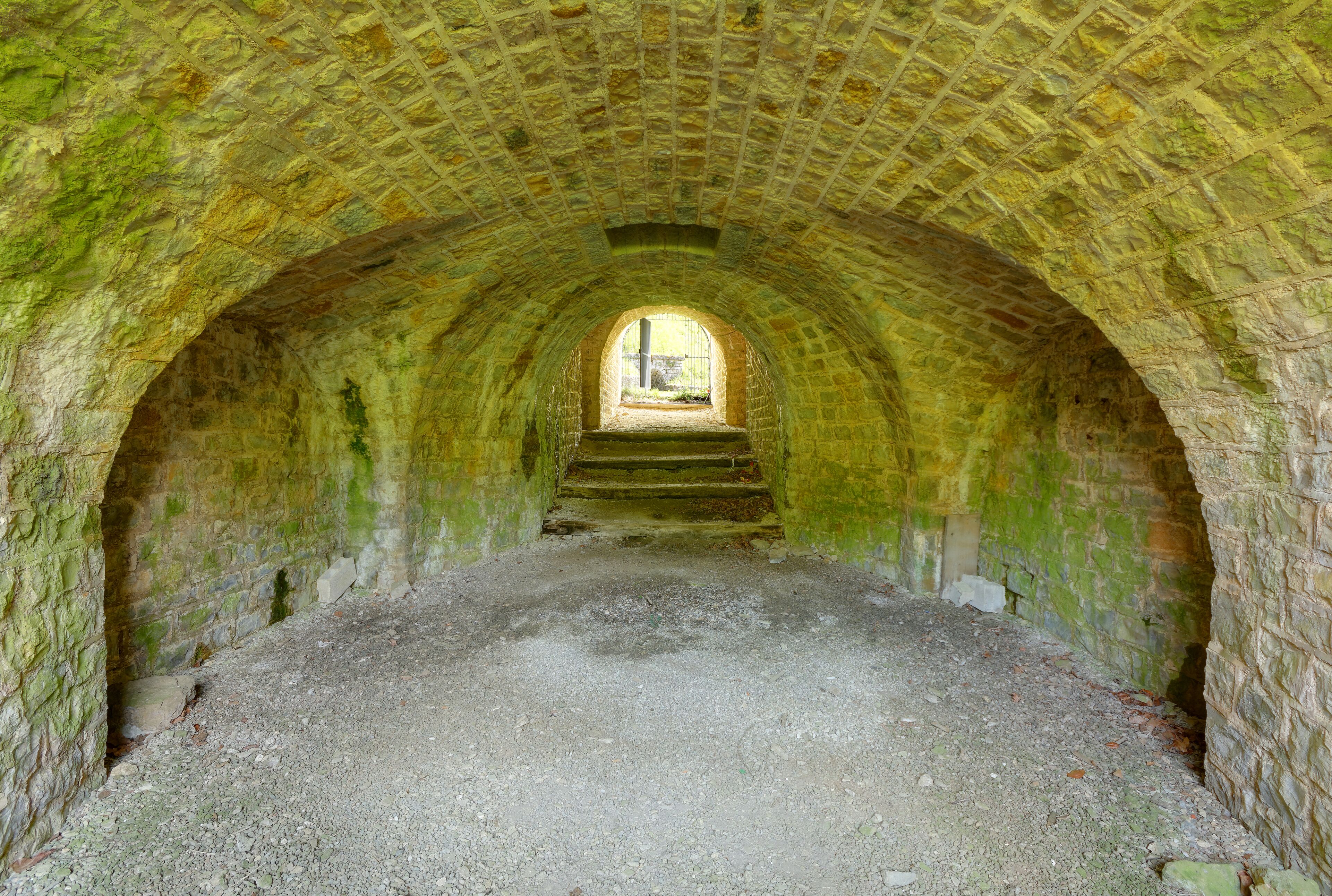 An arched stone tunnel with a window at the far end.