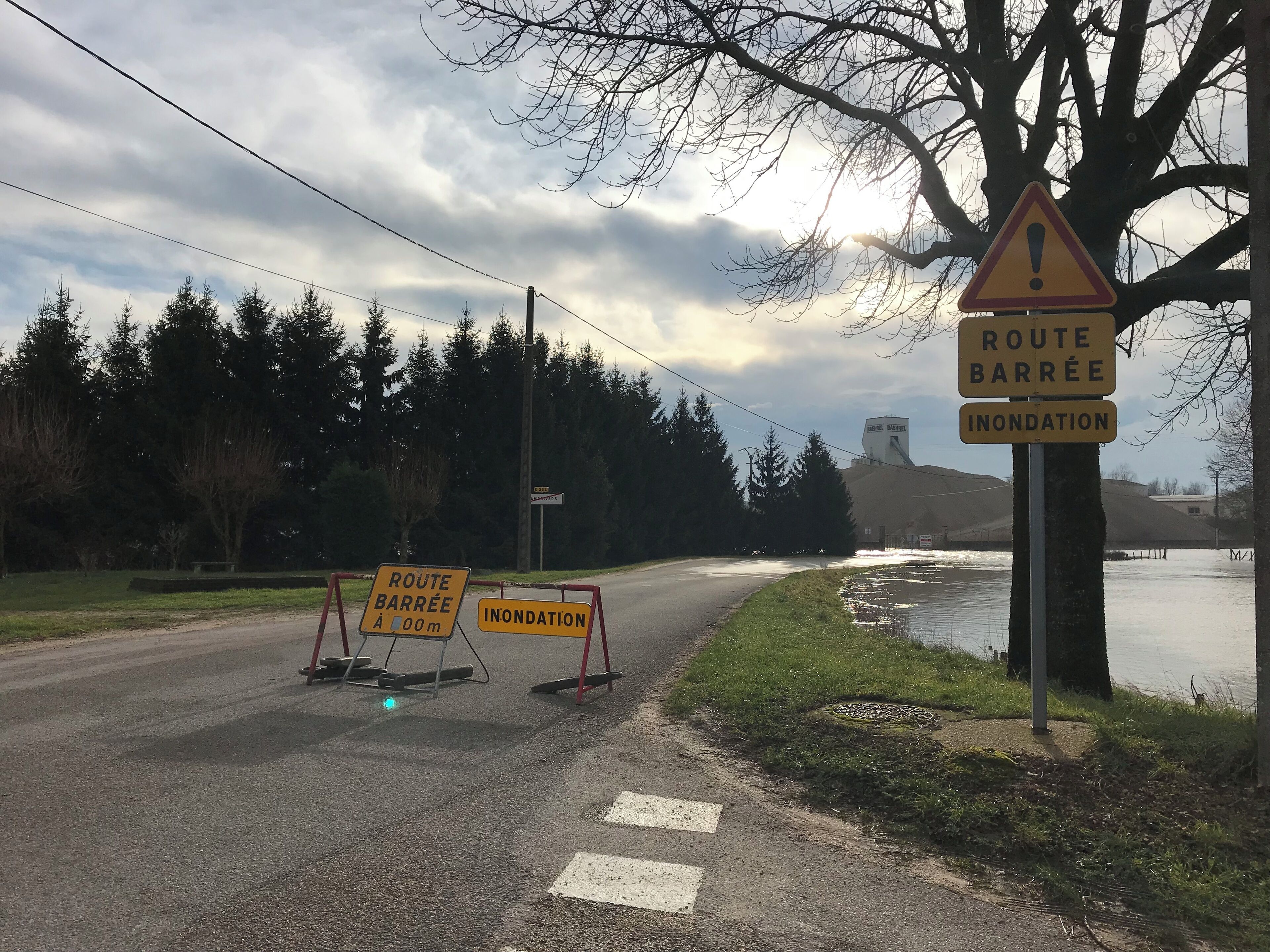 A road closure with signs indicating 'Route Barrée' and 'Inondation'.