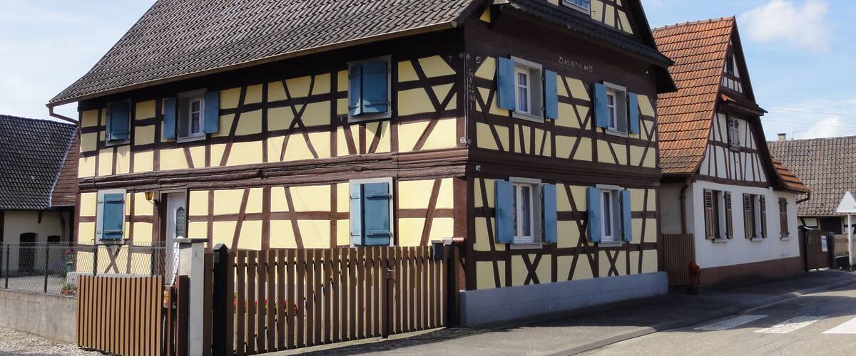 A traditional half-timbered house with a steeply pitched roof and multiple windows.