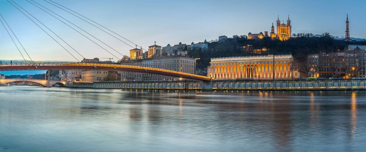 A river with a bridge, a cathedral, and a tower.