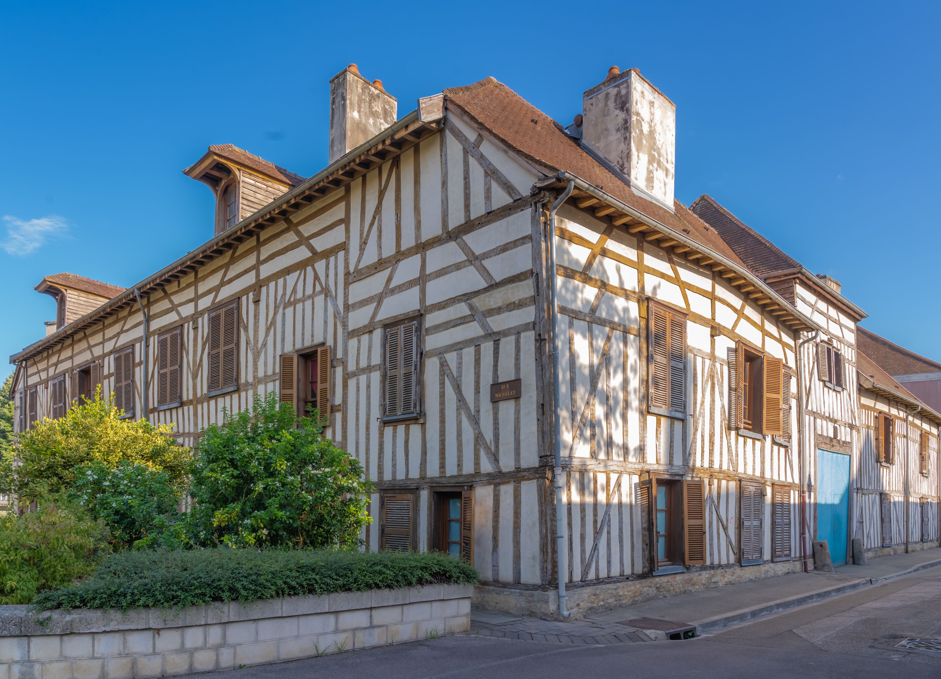 A half-timbered building with a sign reading "Hôtel de Ville" and a blue door.