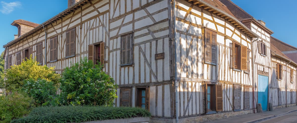 A half-timbered building with a sign reading "Hôtel de Ville" and a blue door.