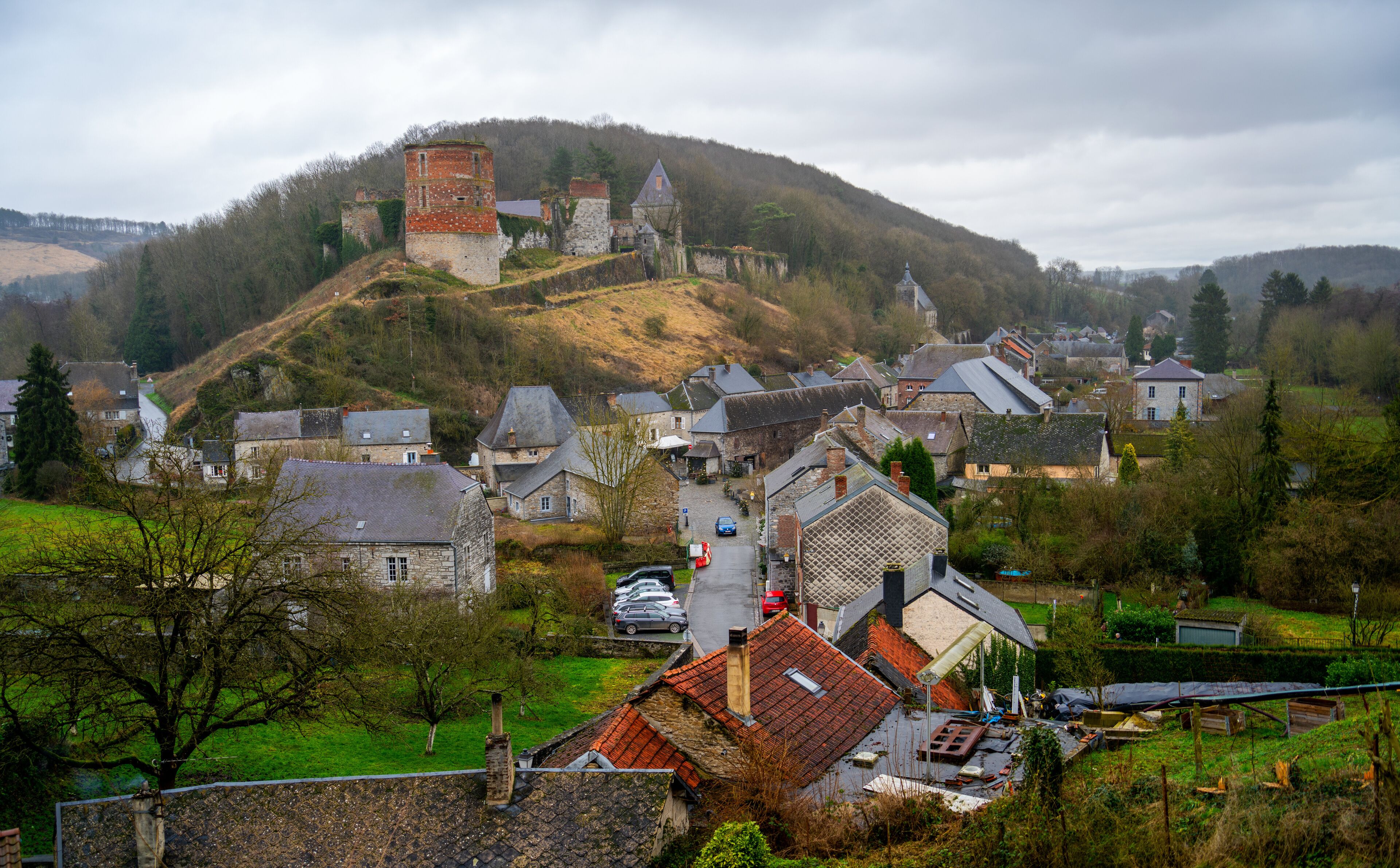 A village with stone houses, a church, and a hilltop tower.