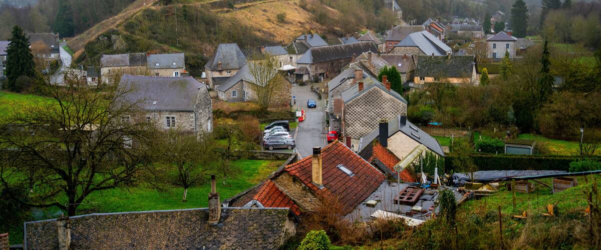 A village with stone houses, a church, and a hilltop tower.