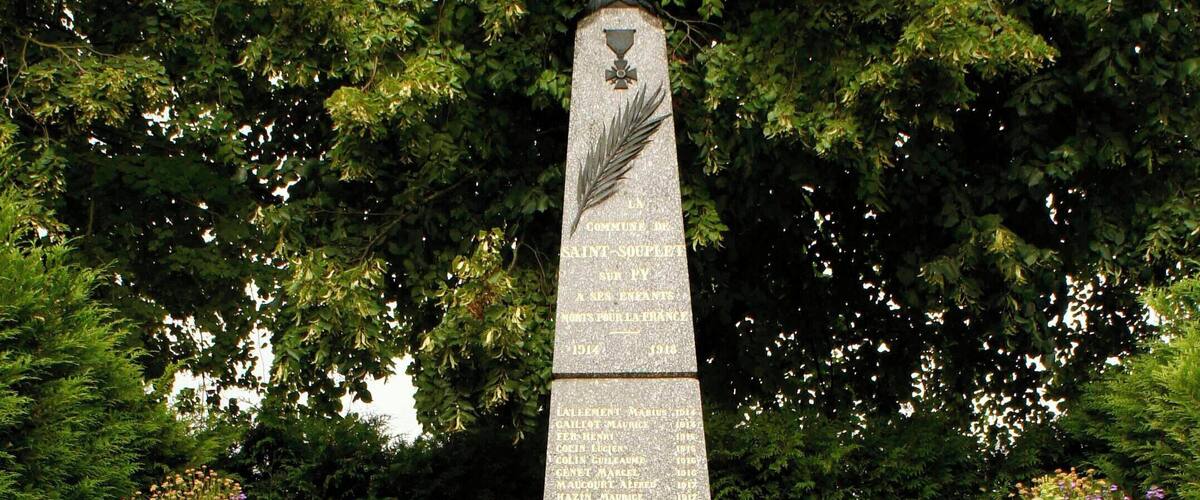 A stone monument with a cross at the top, surrounded by a staircase leading up to it.