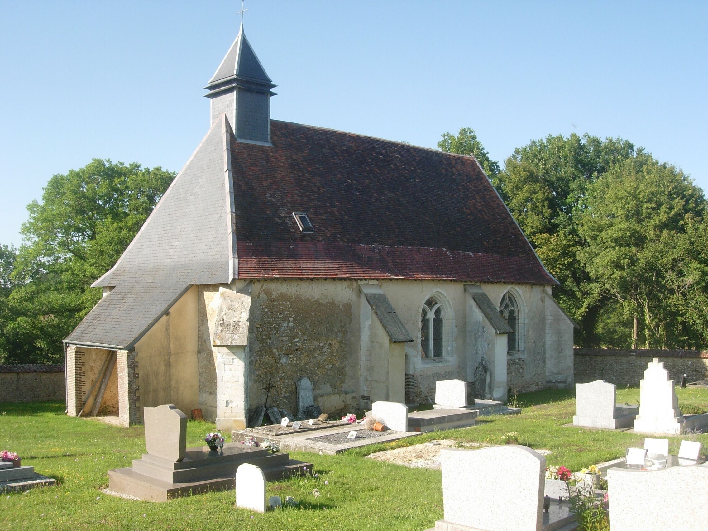 A church with a steeple and a graveyard.