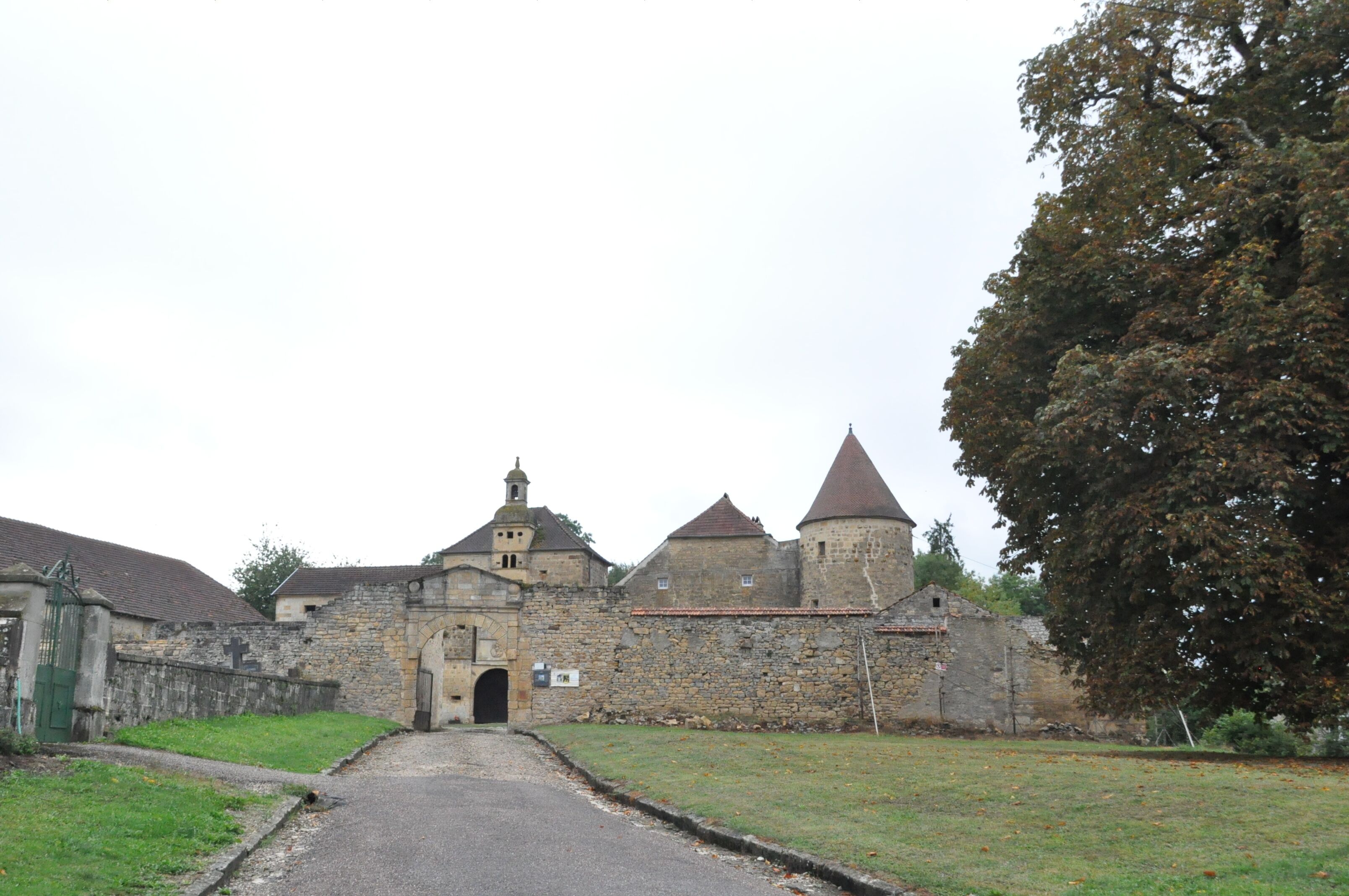 A historic stone building with a central archway and a tower.