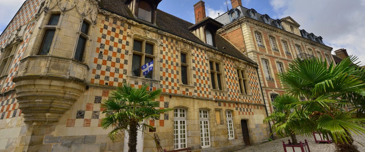 A historic building with a checkered facade and a flag.