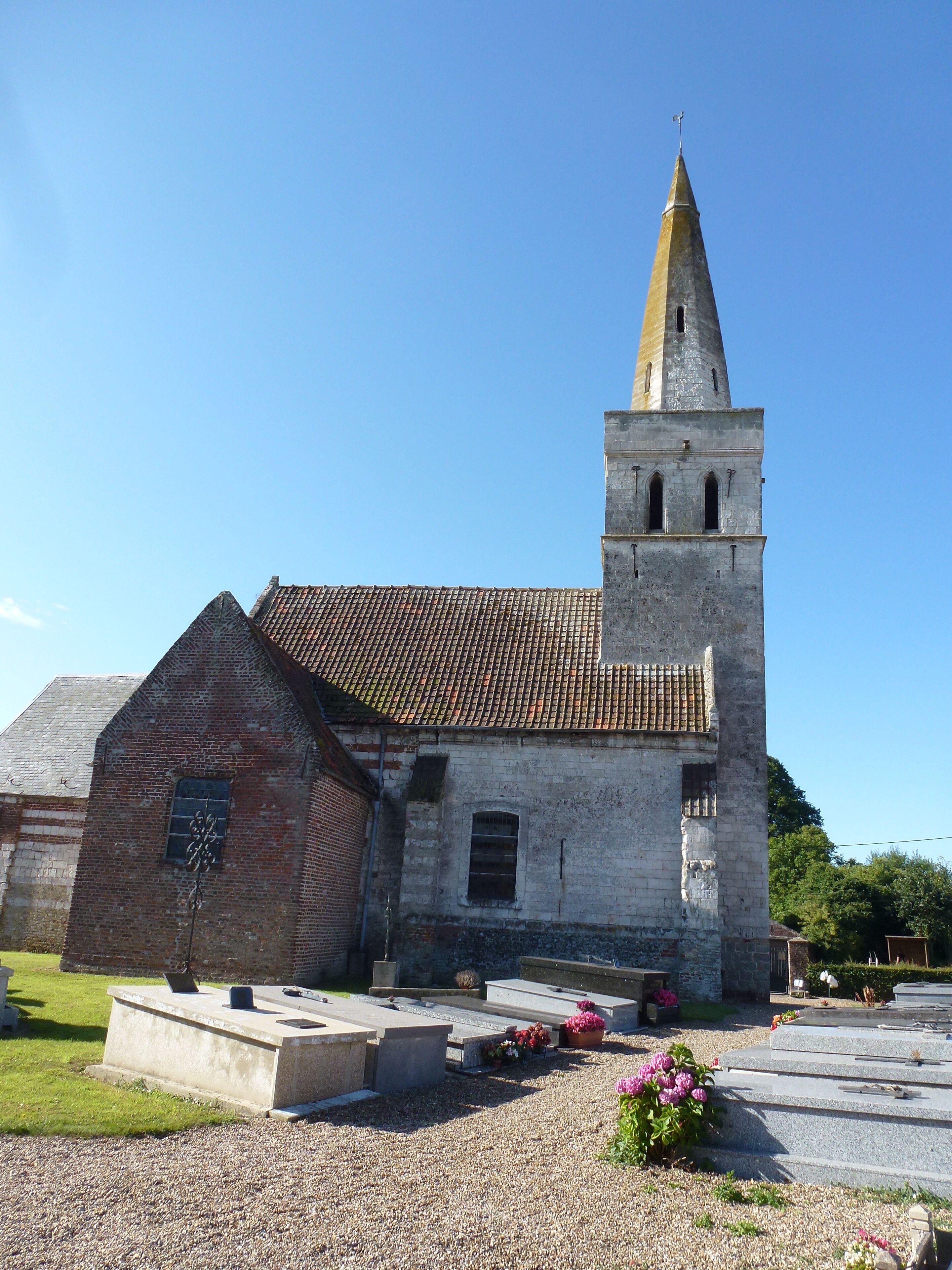A church with a tall bell tower and a brick building.