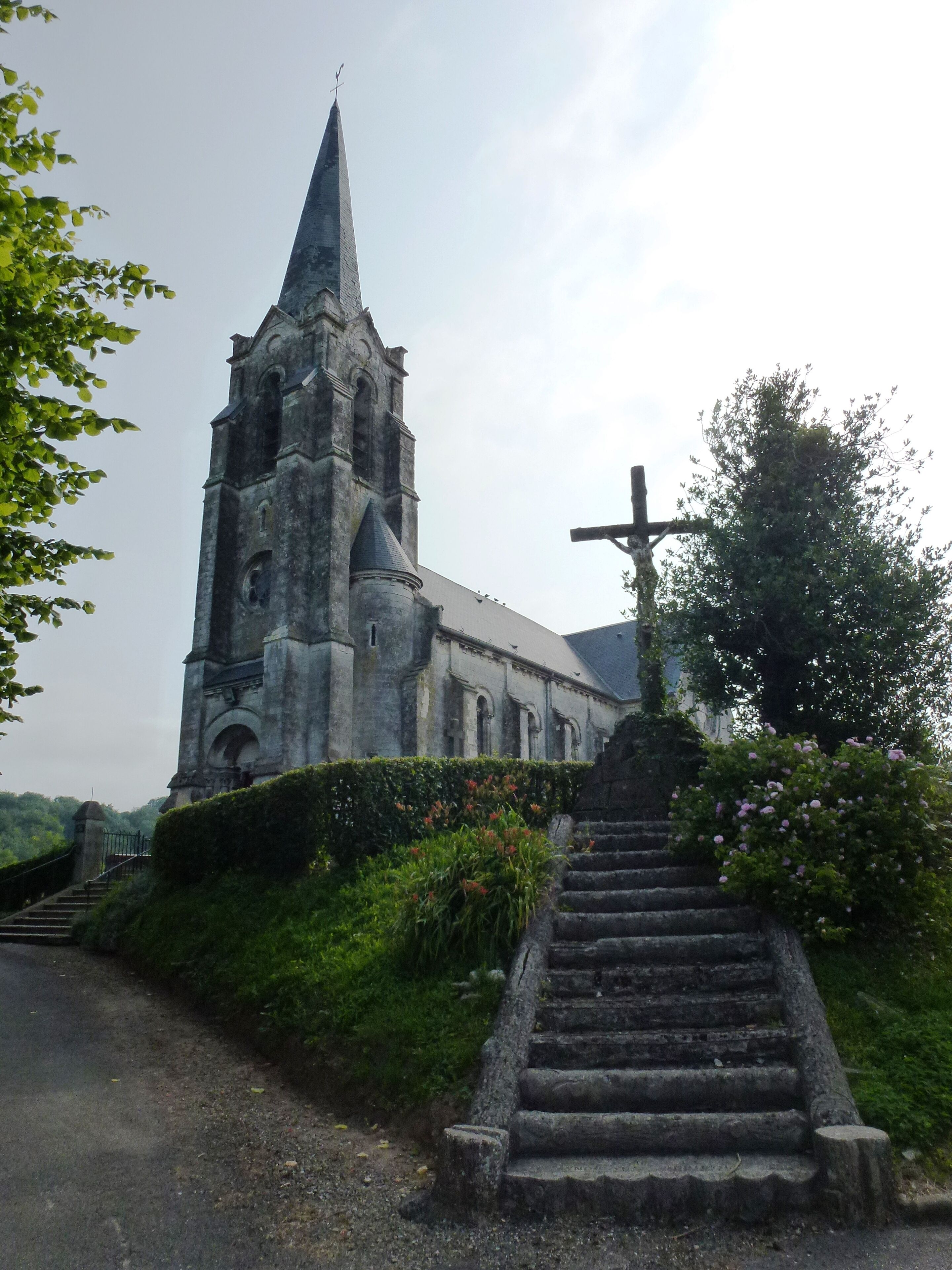 A church with a tall spire and a cross on the roof.