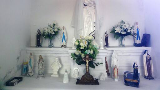 Exhibición religiosa con estatuas y flores.
