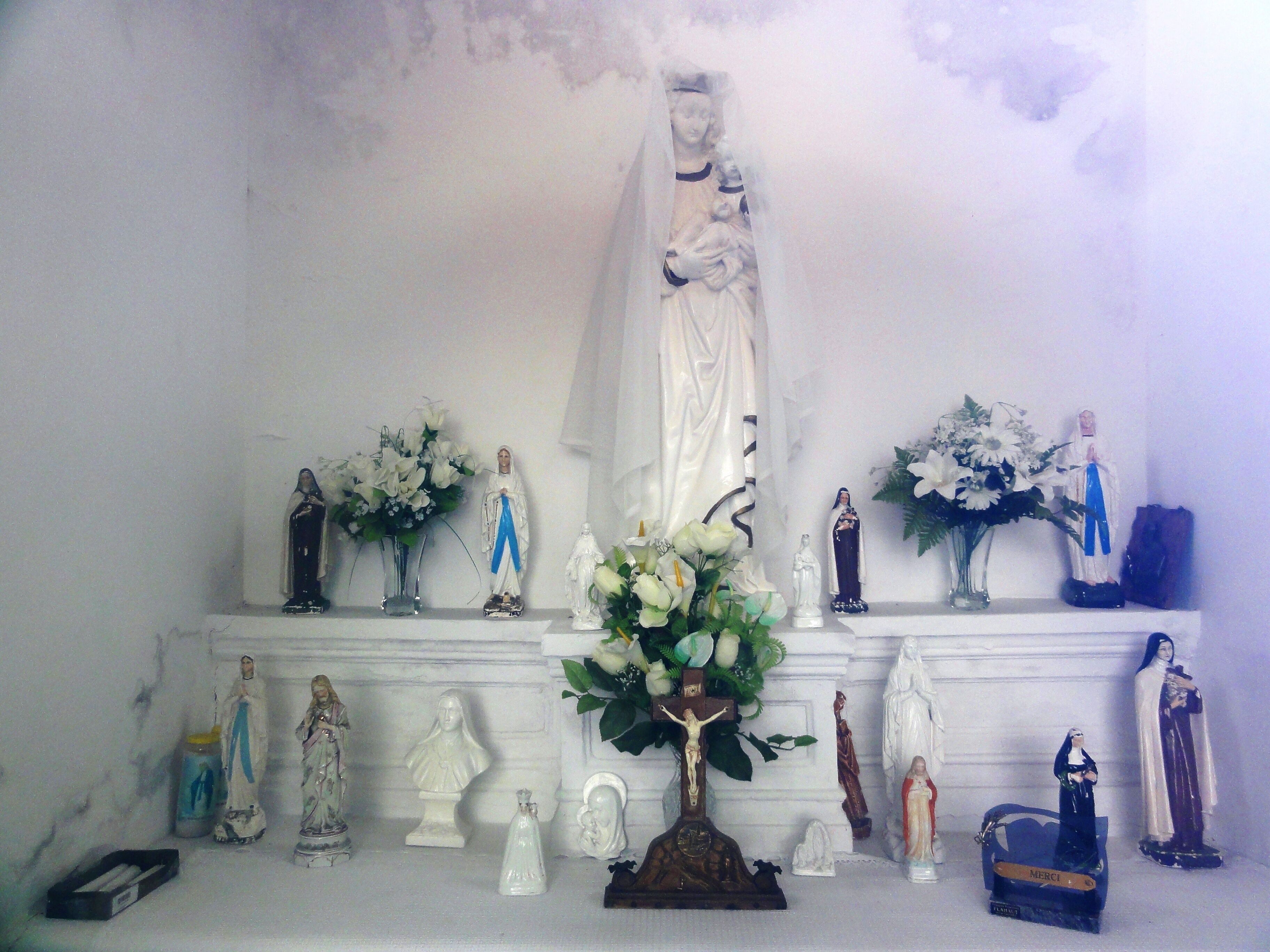A religious display with statues and flowers.