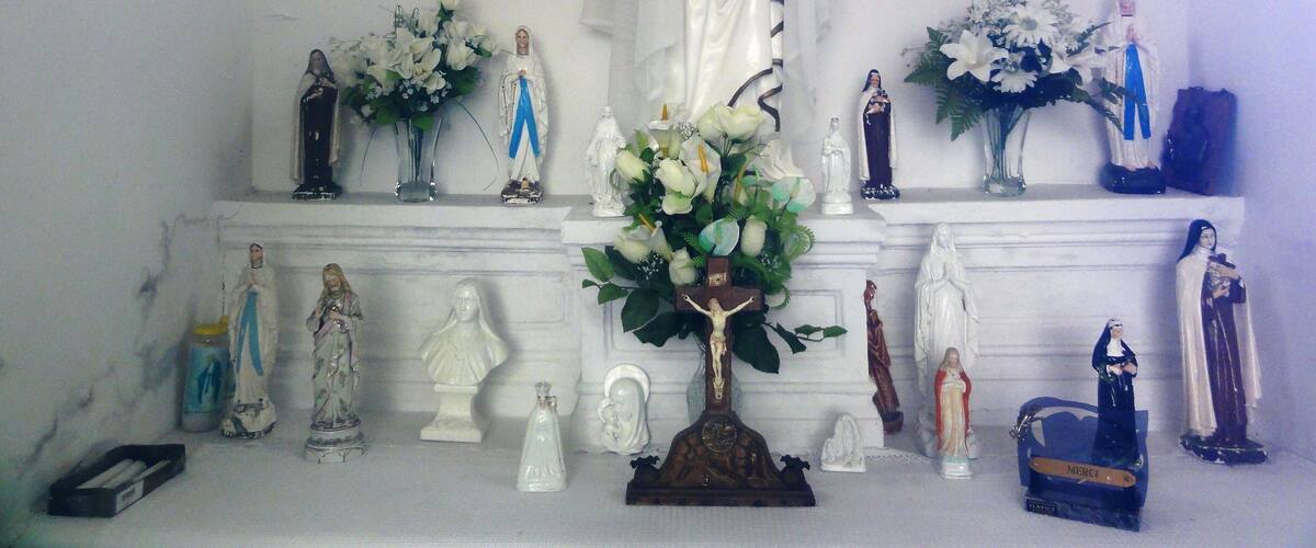 A religious display with statues and flowers.