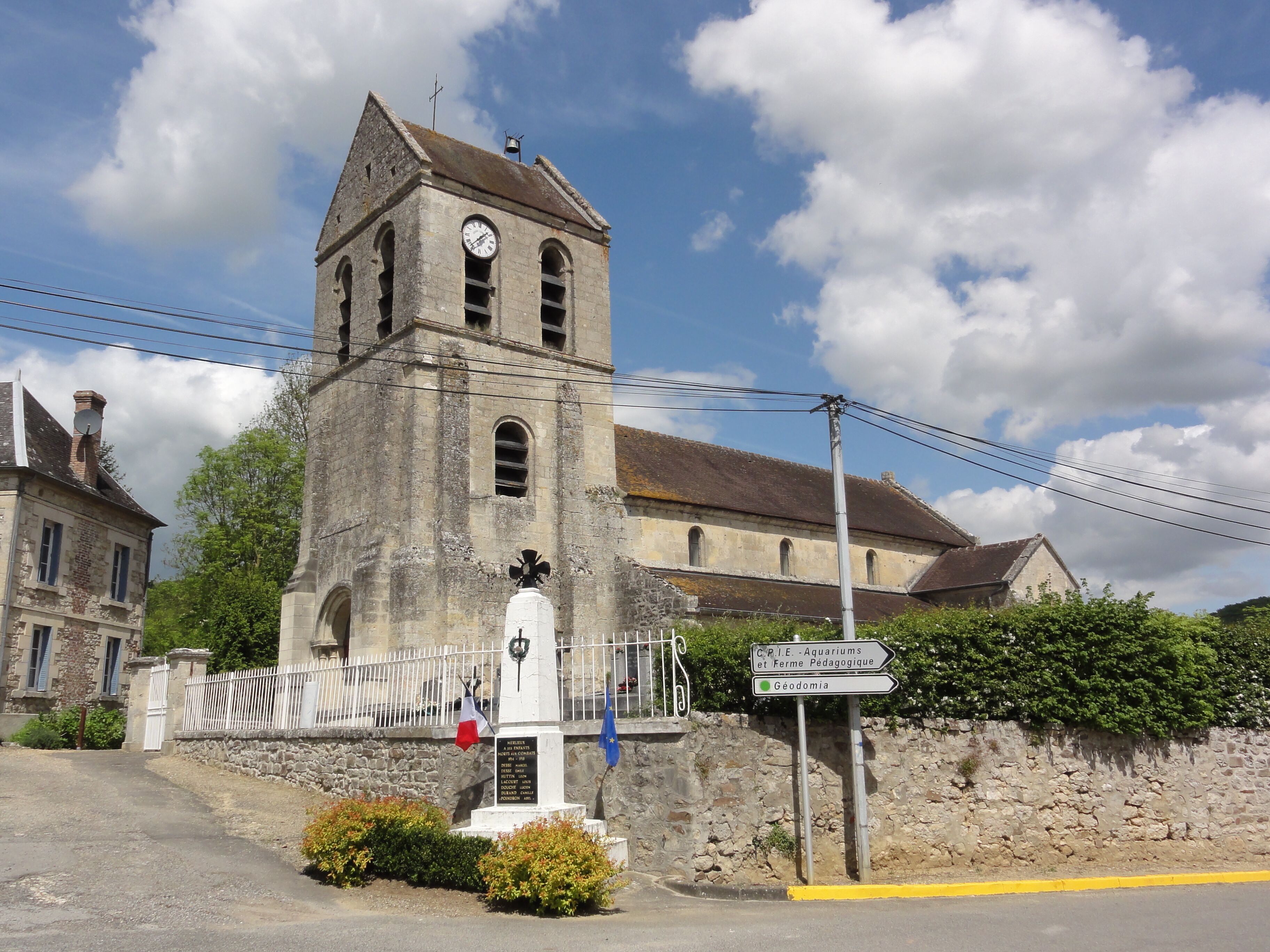 A historic church with a bell tower, a clock, and a memorial plaque.