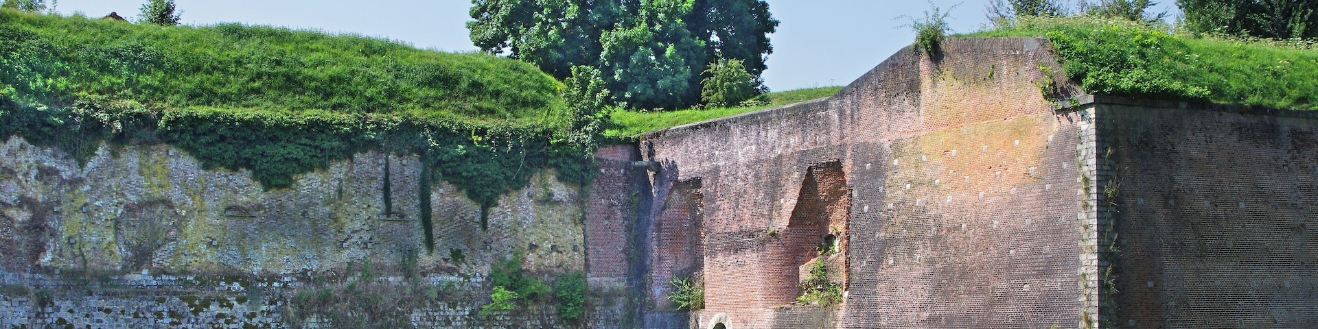 Les remparts, édifiés à l'époque espagnole et remaniés par Vauban et ses successeurs jusque 1914. Le soubassement de grés permet d'isoler la maçonnerie de briques de l'humidité du fossé.