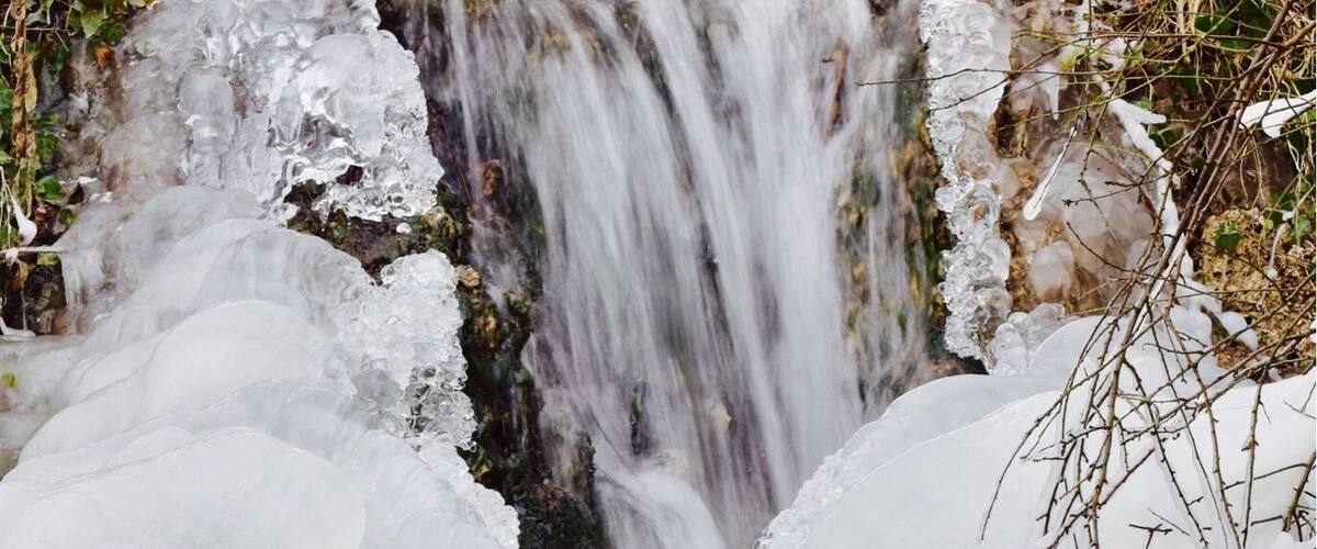 A waterfall partially covered by ice.
