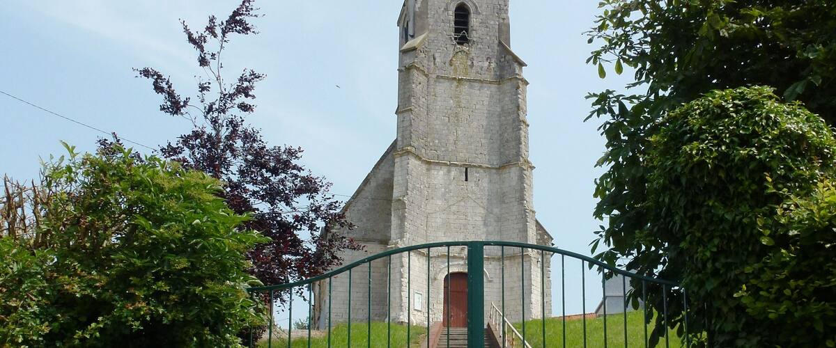 A church with a tall steeple and a gated entrance.