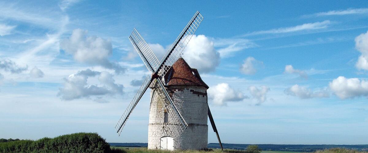 A windmill in a rural setting with a clear sky.