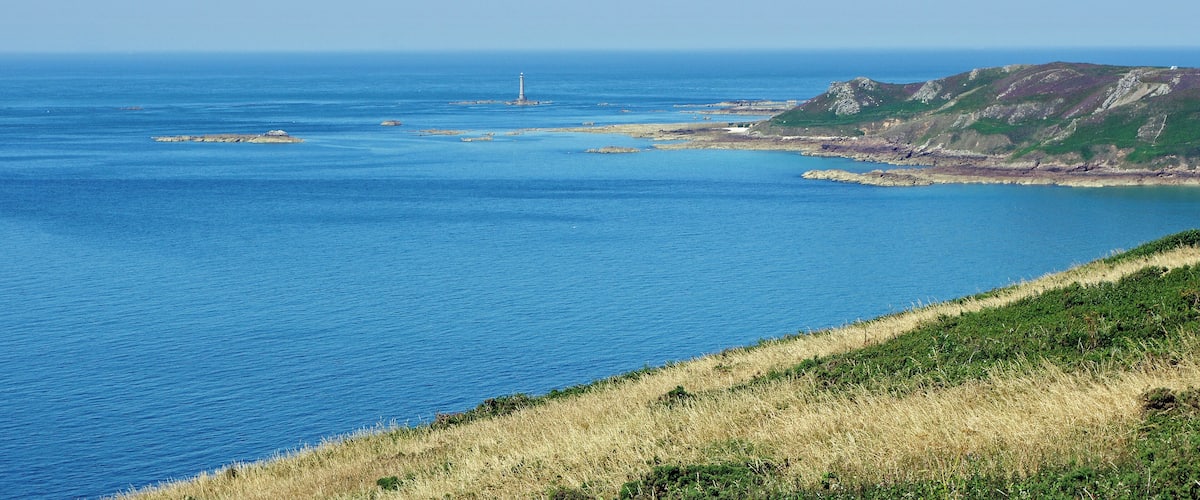 Jobourg (Manche) Le phare de Goury vu depuis le Nez des Voidries. Au large du cap de la Hague, les naufrages Ă©taient trĂšs nombreux, pendant la seule annĂ©e 1823, 27 navires ont sombrĂ© dans les parages. Il fut donc dĂ©cidĂ© la construction d'un phare sur le Gros du Raz, rocher sĂ©parĂ© du littoral par un canal dâenviron 800 m de largeur. Les Ă©tudes commencĂšrent en 1834 et la construction, en granit, fut achevĂ©e en 1837. Le phare a Ă©tĂ© allumĂ© pour le premiĂšre fois le 1er novembre 1837. Le phare de Goury, a une hauteur de 48 mĂštres. Sa portĂ©e est de 25 kilomĂštres. La rotation de la lanterne est continue et elle dĂ©livre un Ă©clat toute les cinq secondes. Fonctionnant d'abord au pĂ©trole, le phare est aujourd'hui Ă©lectrifiĂ©. Pendant la deuxiĂšme guerre mondiale, le phare resta Ă©teint et ne fut rallumĂ© qu'Ă la libĂ©ration, dĂ©but juillet 1944. Le phare est automatisĂ© depuis 1988 et il n'y a plus de gardiens depuis 1990.