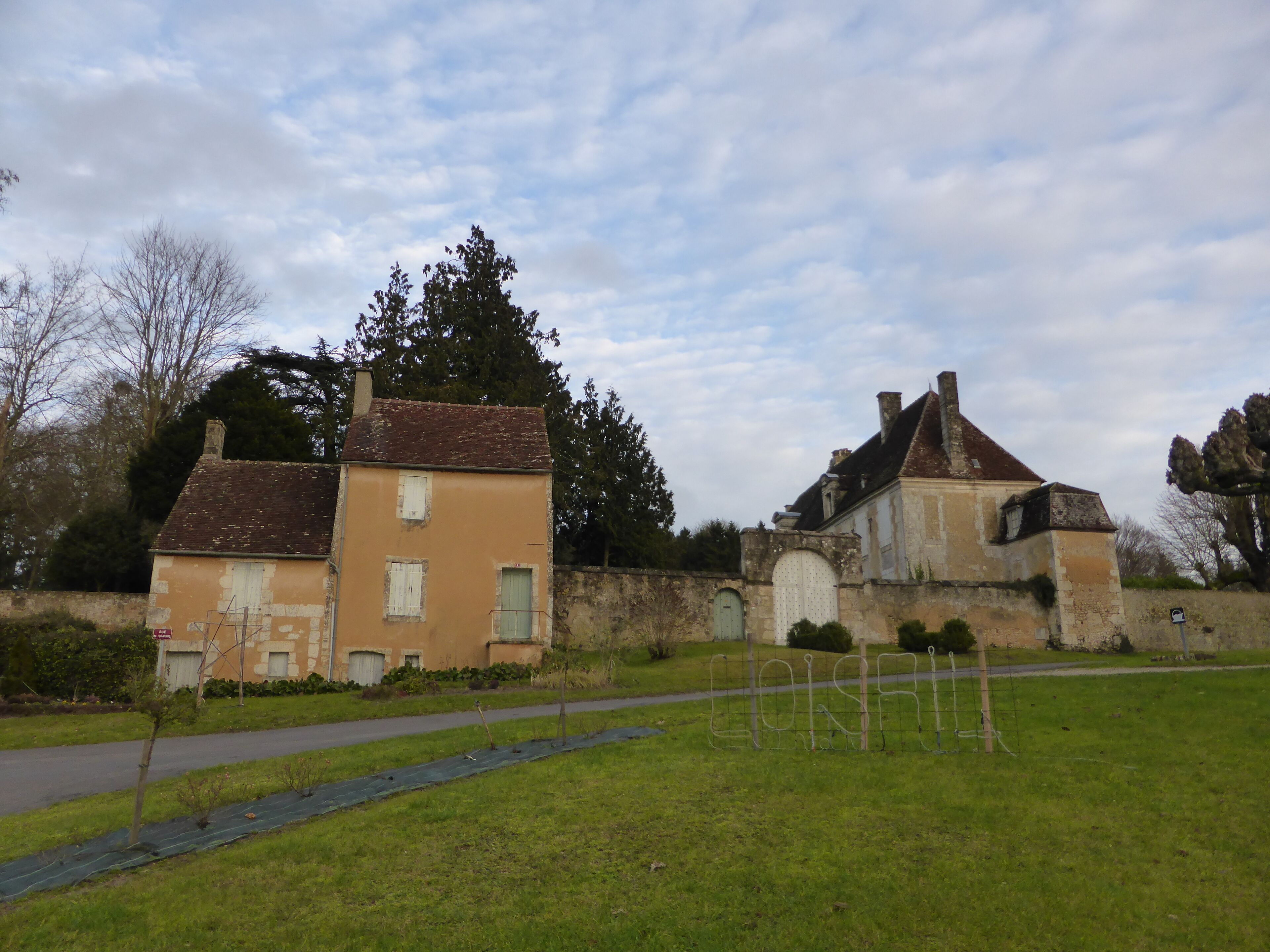 A historic building with a stone wall and a paved path.