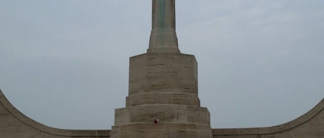 A tall cross monument with a base and steps leading up to it.