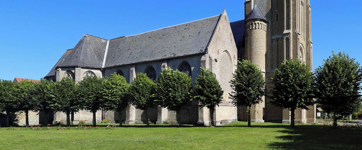 A Gothic church with a tall spire and a smaller building with a sloped roof.