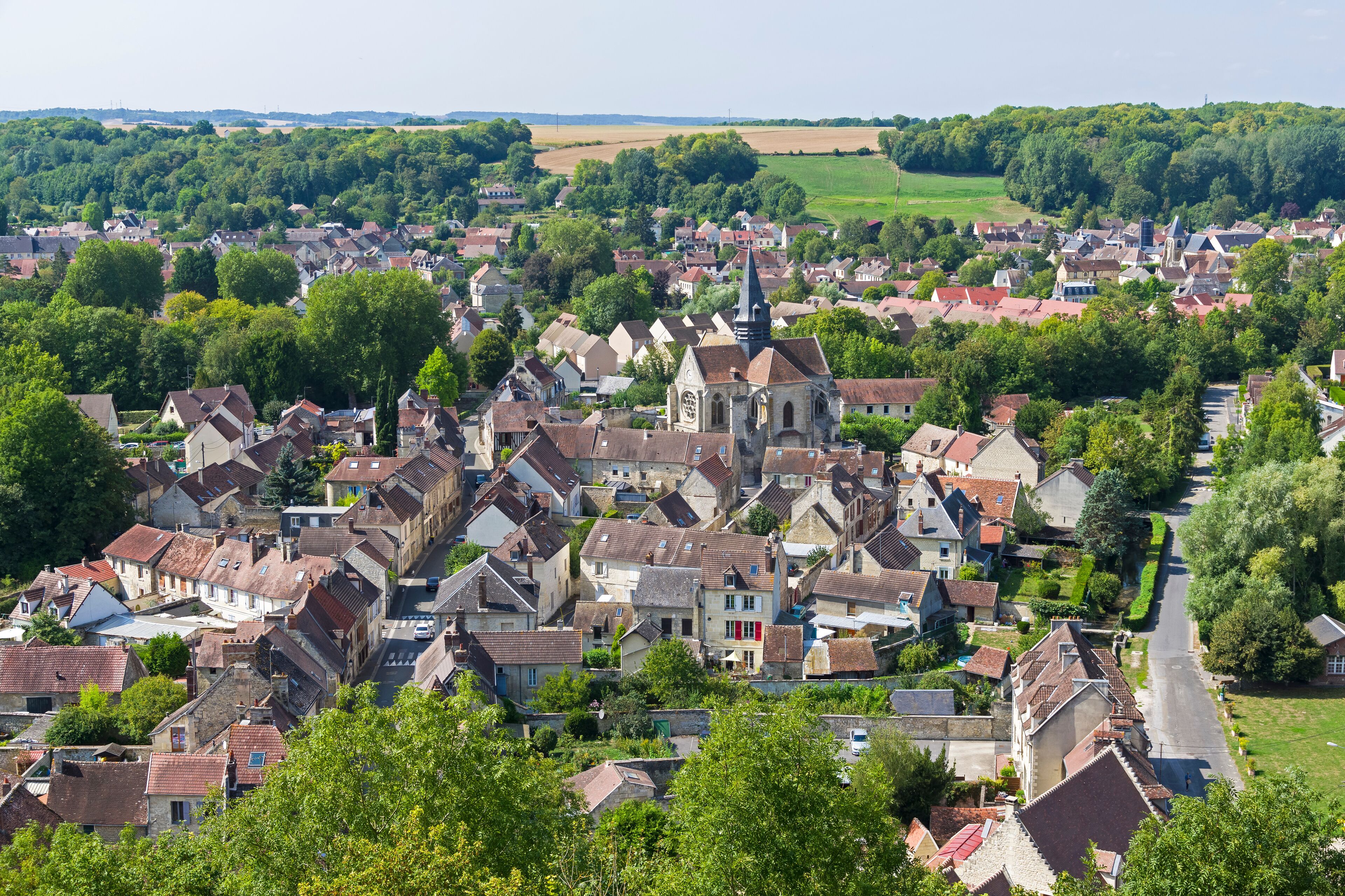 A historic town with a prominent church, surrounded by lush greenery and rolling hills.