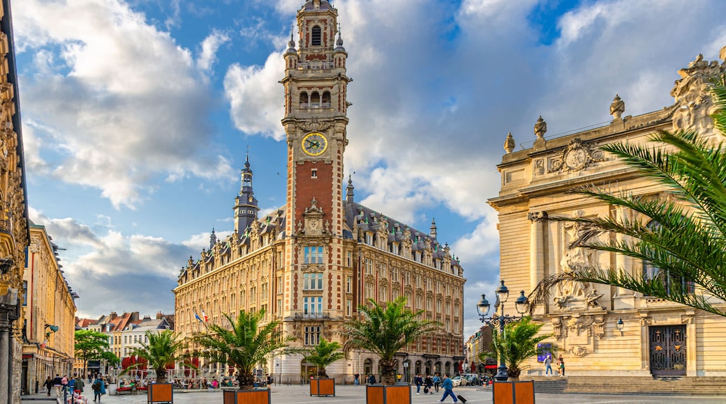 A historic building with a clock tower, palm trees, and a clear blue sky.