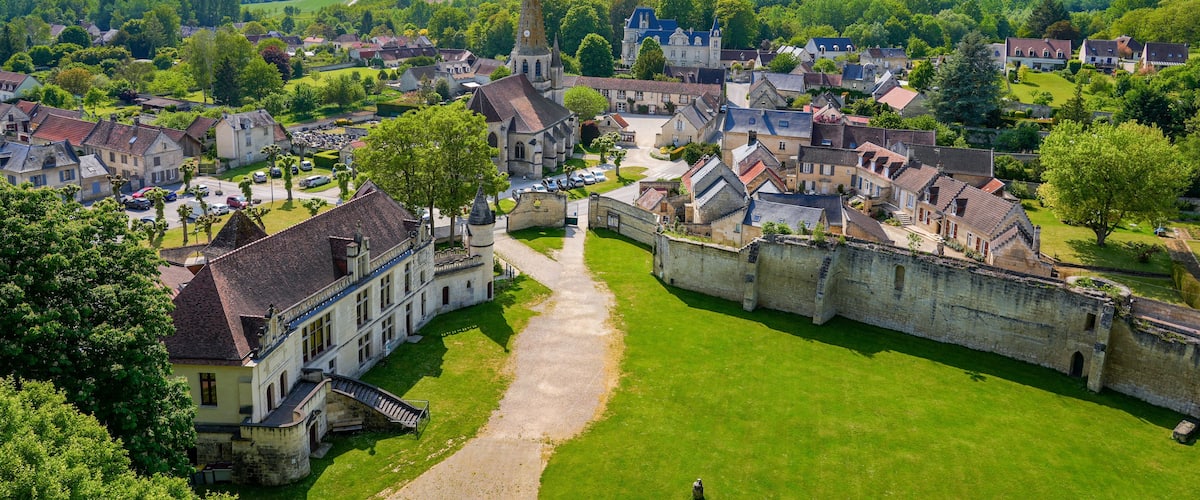 A historic town with a prominent church, a castle, and lush green surroundings.