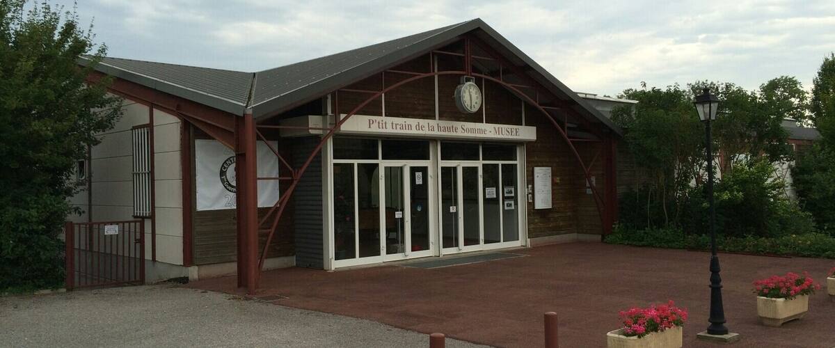 A museum building with a clock and a sign that reads "P'tit train de la haute Somme - MUSEE".