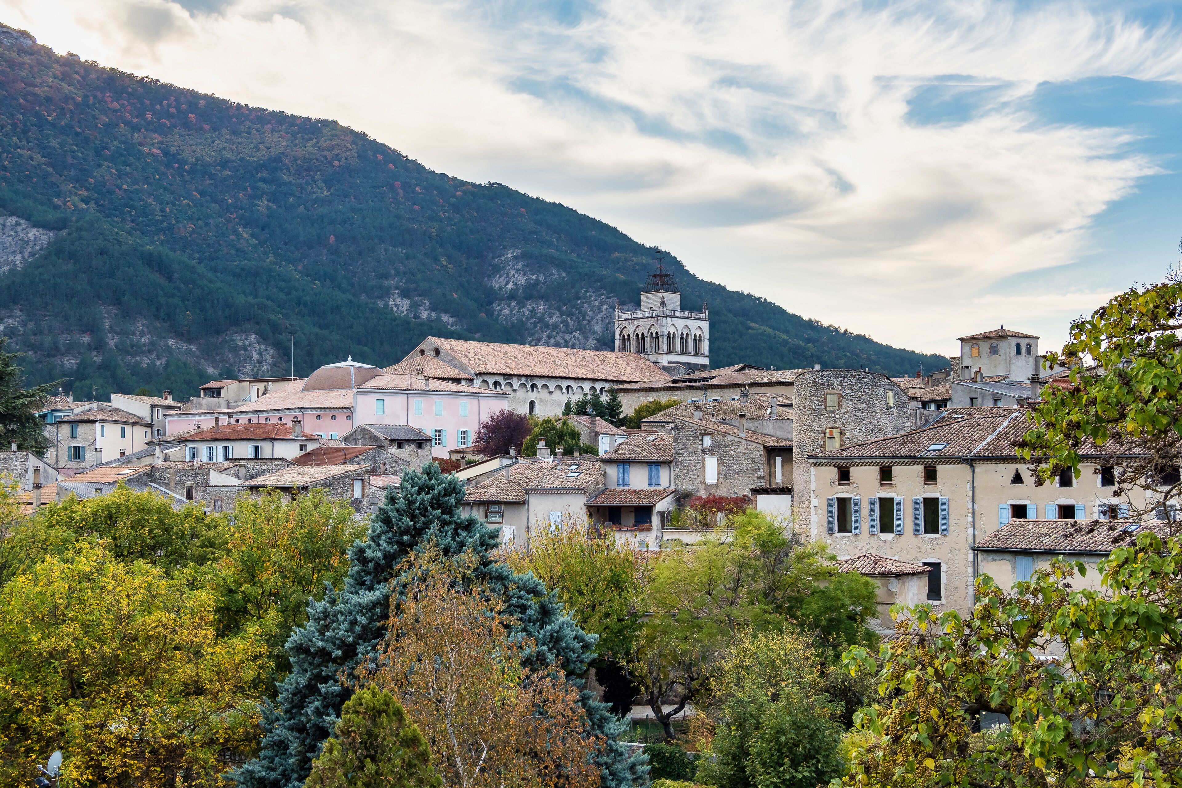 A mountainous village with historic buildings and a prominent tower.