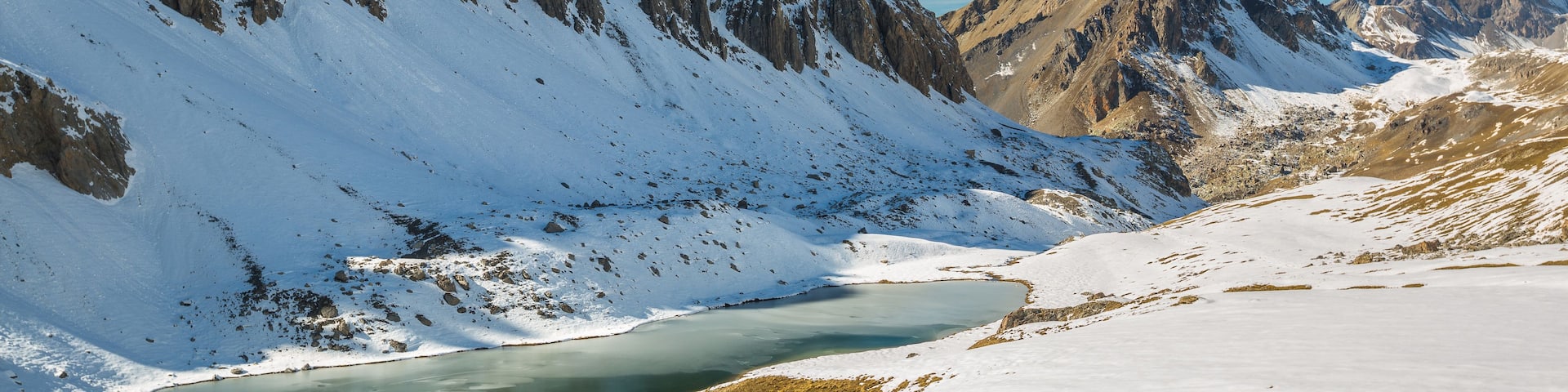 A snow-covered mountain landscape with a clear blue sky.