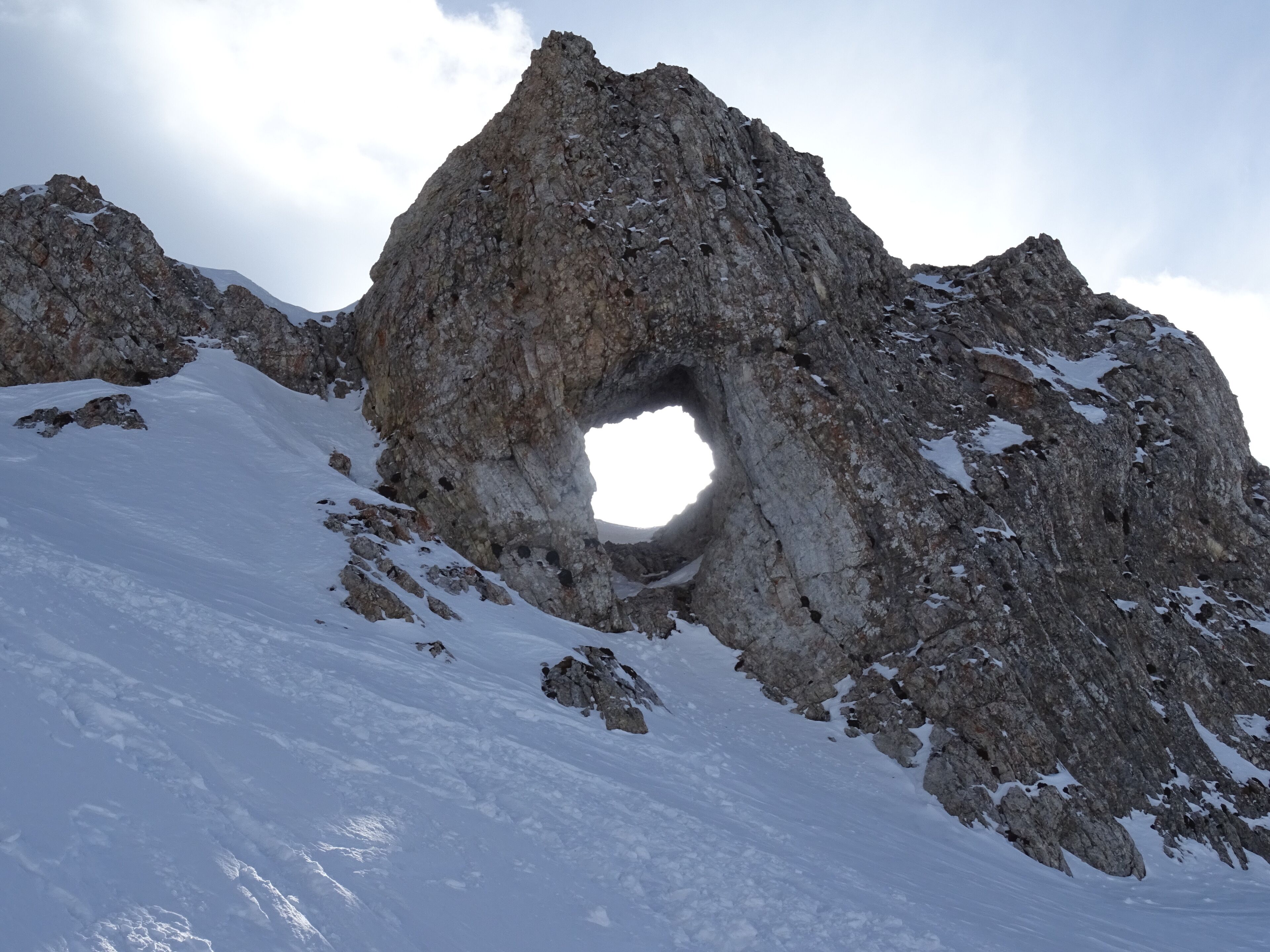 A rocky mountain with a large cave-like opening.