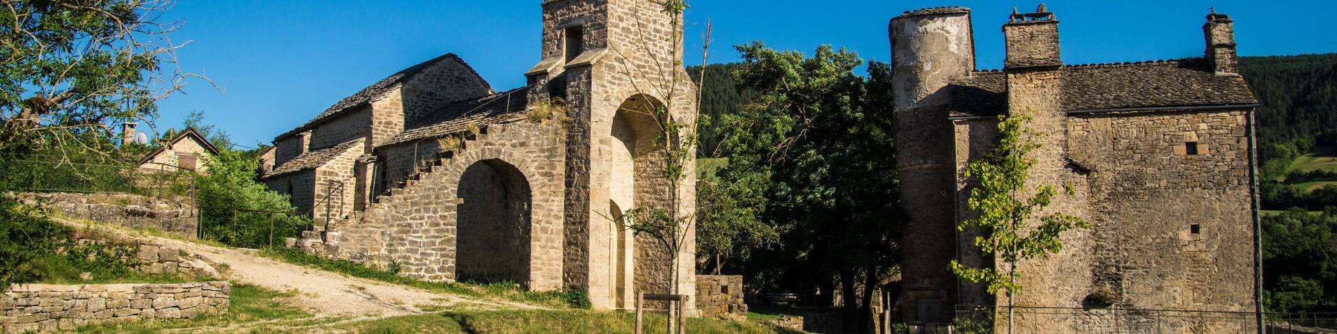 A historic stone church with a bell tower and arched windows.