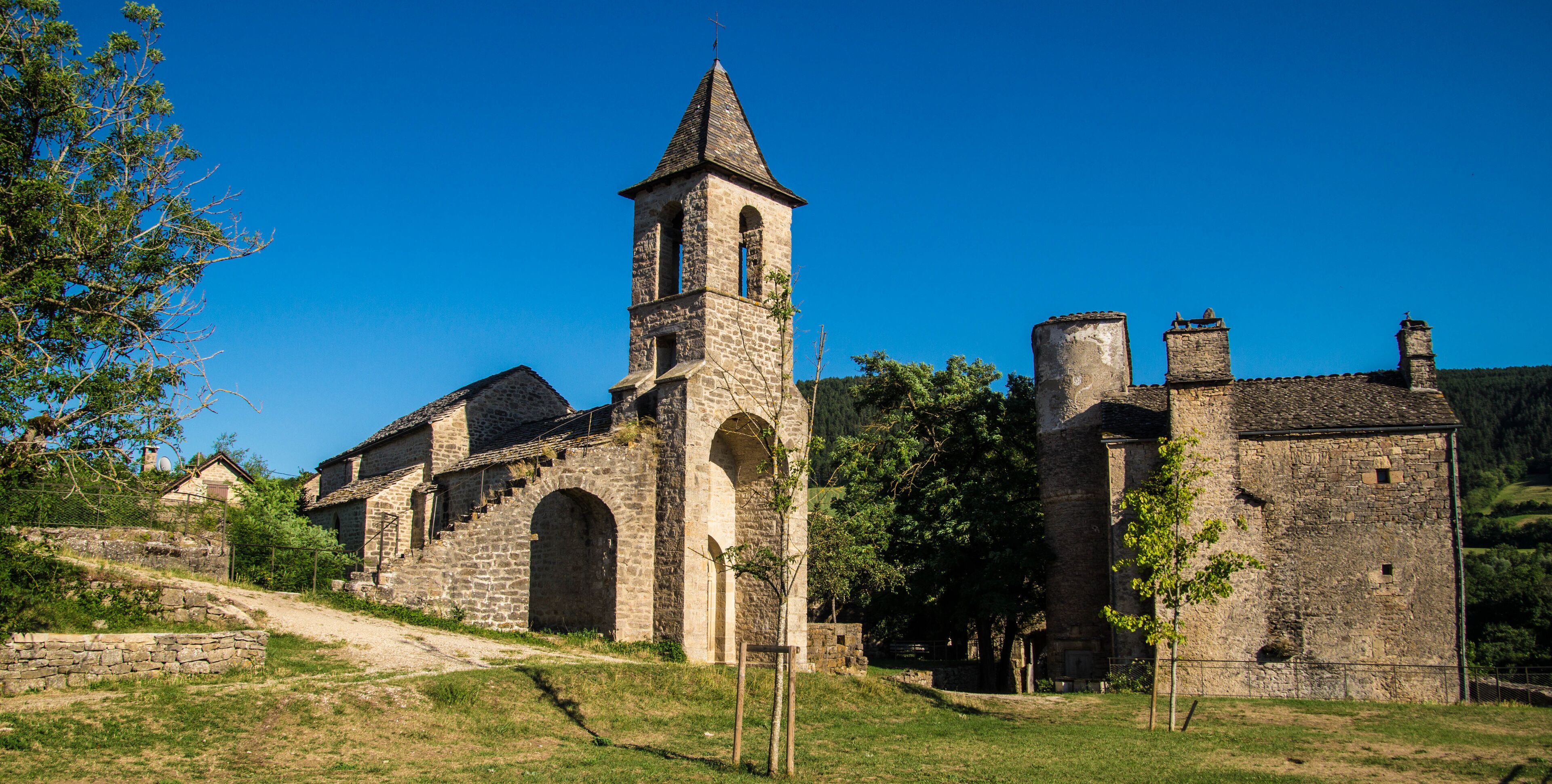 A historic stone church with a bell tower and arched windows.