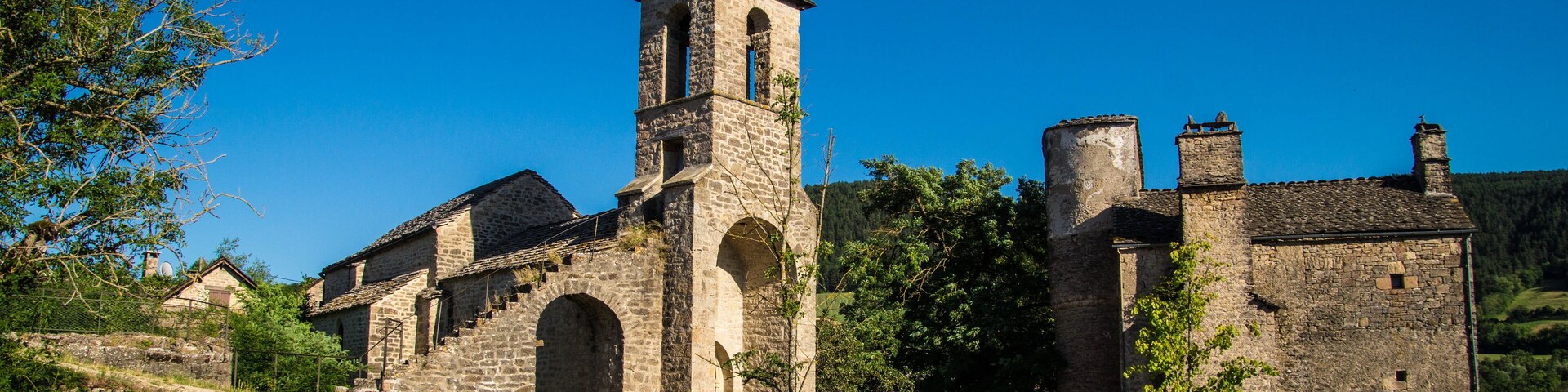 A historic stone church with a bell tower and arched windows.